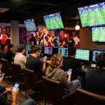 Dynamic sports betting scene showcasing tỷ lệ kèo nhà cái on multiple screens as eager bettors analyze odds.