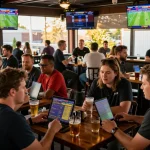 Betting excitement at 789win1 as sports fans wager on multiple screens in vibrant bar setting